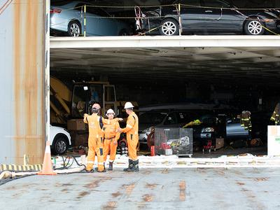 Response team assessing damaged vehicles inside the car carrier's cargo deck